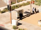 Two people take refuge from the scorching sun in the shade offered by a streetlight pole. Tall buildings also absorb and amplify the heat of the sun. A view of downtown Phoenix. © Cassidy Araiza.