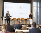 Julie and Kevin present to a room of conference attendees.