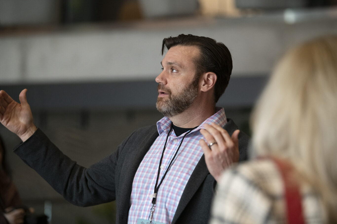 Slide 4 of 6, Kevin Rodenkirch gestures widely to demonstrate architectural elements to a crowd of tour-goers.