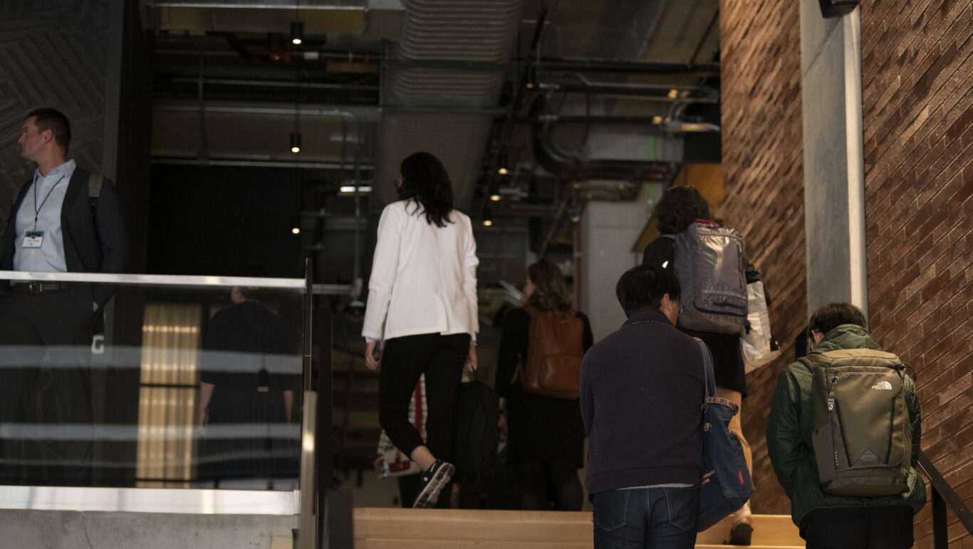 Slide 6 of 6, A group of tour-goers walk up the stairs on a tour of 800 Fulton Market.