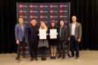 Award recipients stand backstage with award certificate in front of AIA Chicago backdrop