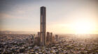 Tall landmark tower overlooking skyline with sun