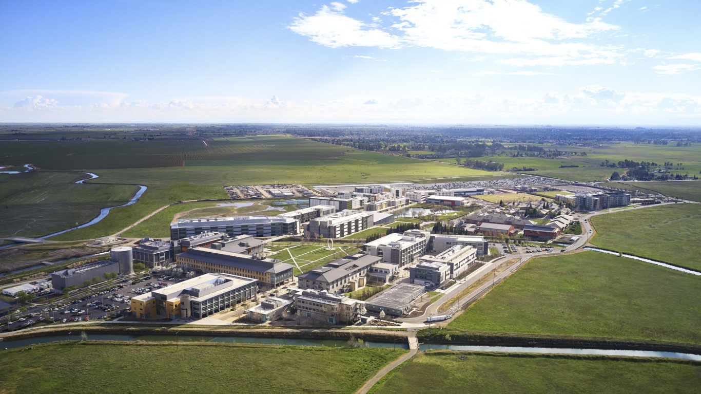Slide 3 of 3, Wide-angle aerial view of the U.C. Merced campus showing the surrounding fields of the San Joaquin Valley.
