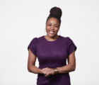 A photo of Tiara Hughes smiling with her hands clasped.